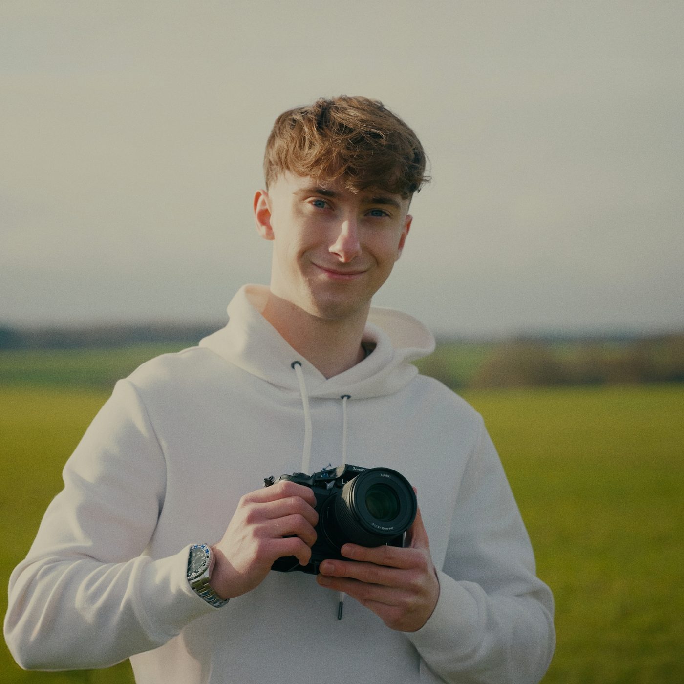 Lucas holding his camera in a field