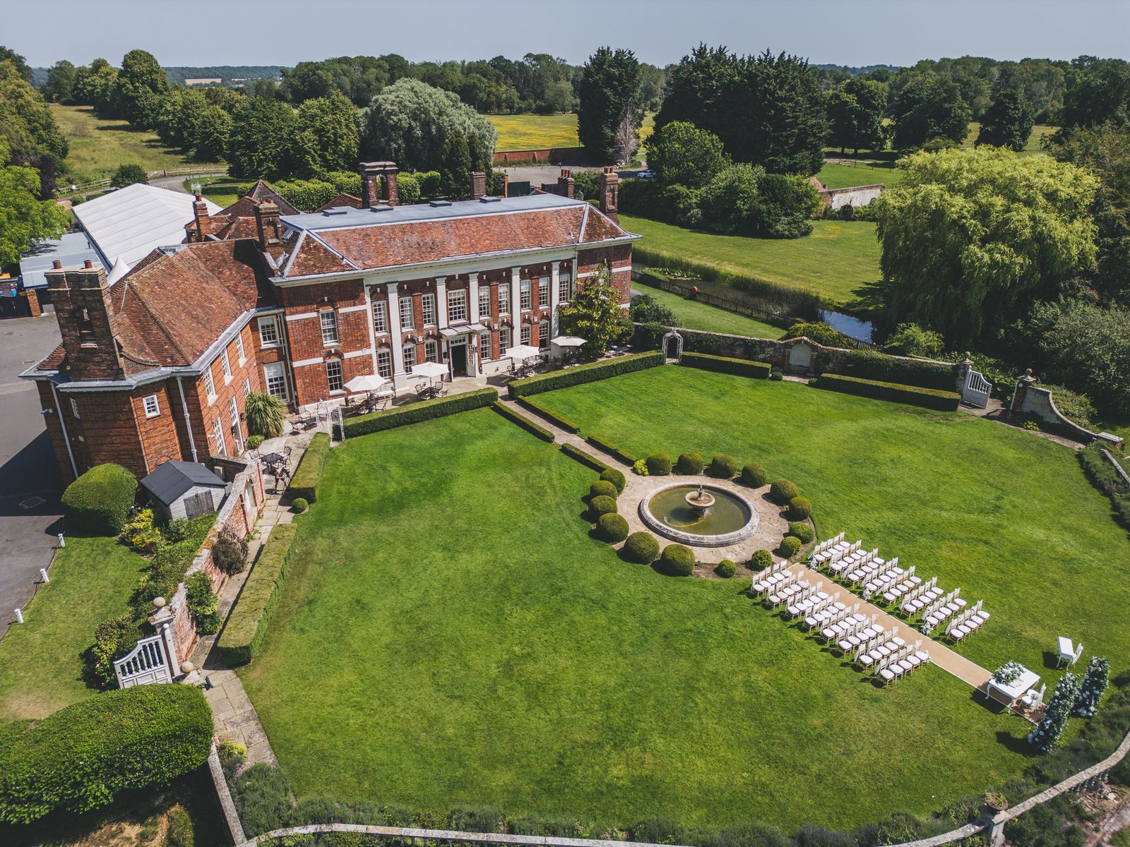 Aerial view of a country house venue set up for an outdoor ceremony